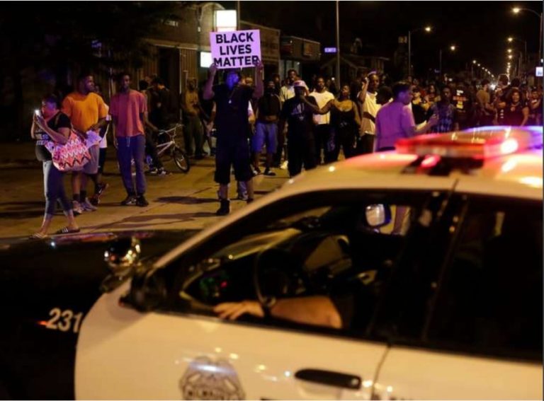 Demonstrators surrounding a police vehicle on Sunday as they protested the fatal shooting of Sylville K. Smith by an officer in Milwaukee.