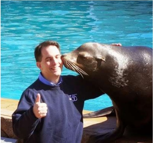 Gov. Scott Walker gamely allowed a trained, 600-lb. sea lion named Slick to give him "kisses" Friday at the Milwaukee County Zoo, as part of Walker's promotion of tourism in Wisconsin.